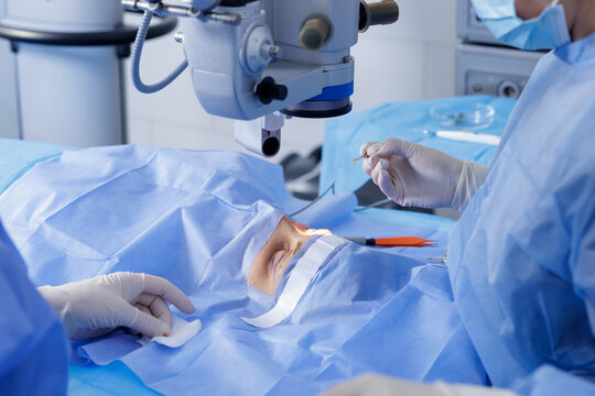 Blepharoplasty under operating microscope with gloved surgeons and sterile drapes