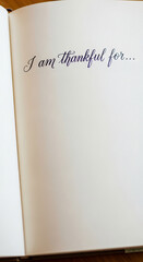 Open notebook page with handwritten text "I am thankful for..." in dark ink, representing gratitude and reflection with ample free space for writing