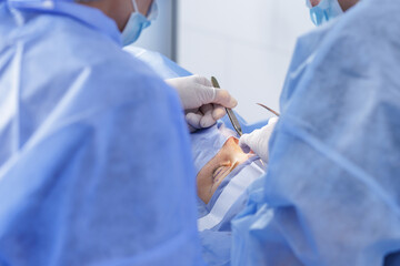 Blepharoplasty eyelid surgery with scalpel and forceps under sterile drapes