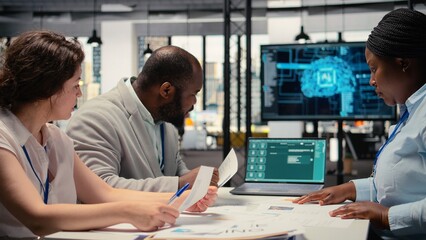 Recruiters reviewing feedback from artificial intelligence platform, using automation and deep learning to make informed hiring decisions and select suitable applicants for employment. Camera A.