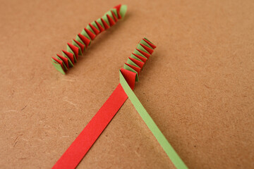 Colorful folded paper strips in zigzag pattern on craft surface, ideal for education, DIY tutorials, kids activities, geometry lessons, school marketing, or creative workshop promotions