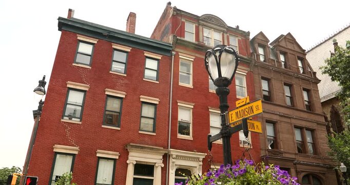 A historic wrought iron street light frames historic architecture in the Mount Vernon neighborhood of Baltimore, Maryland, USA.