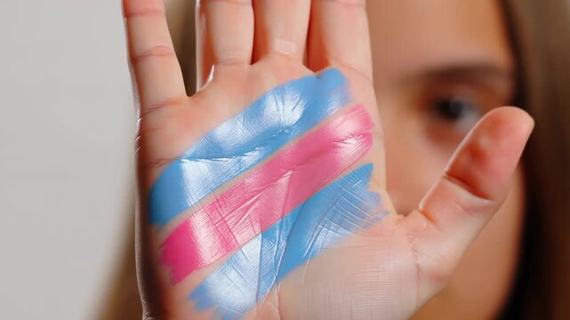 Person showing hand with transgender pride flag