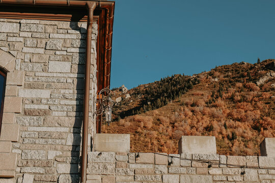 castle brick ramparts copper gutters and fall orange and green colorful trees on the mountains