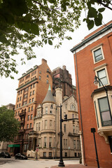 Obraz premium Morning sun shines on beautiful historic building architecture in the heart of the Mount Vernon neighborhood of Baltimore, Maryland, USA.