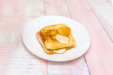 Triple club sandwich with chicken breast, crispy bacon, lettuce, and tomato between three layers of toasted white bread