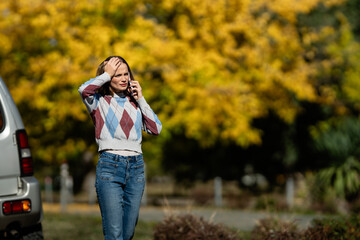 Woman experiencing car trouble making a phone call