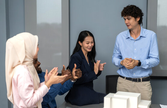 Architects engineers collaborating on building design project in modern office, diverse team of professionals female muslim architect and male engineers discussing architectural model of structure - Powered by Adobe