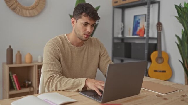 Man opens laptop and starts typing at home, computer activities attract guy young hispanic to desk concentration.