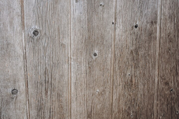 Rustic wooden wall texture with natural grain and knots. Weathered barn wood background for design, vintage or countryside themes.