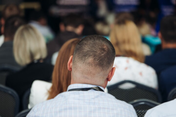 Audience at the modern conference hall listens to panel discussion, people on a congress together listen to speaker on stage at convention, plenary session at business seminar, venue for presentation