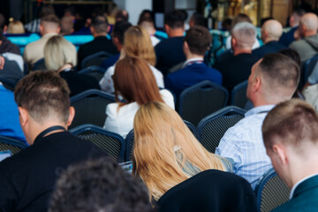 Audience at the modern conference hall listens to panel discussion, people on a congress together listen to speaker on stage at convention, plenary session at business seminar, venue for presentation