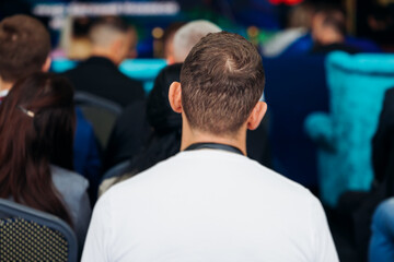 Audience at the modern conference hall listens to panel discussion, people on a congress together...
