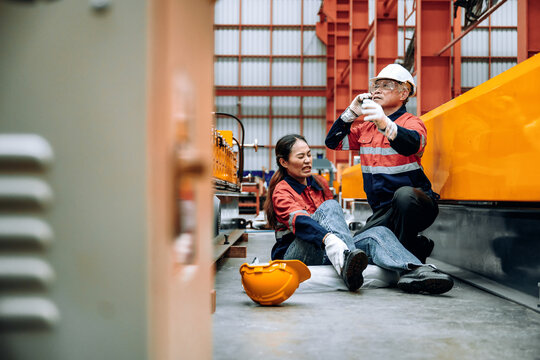 Senior Technician Calling Emergency Help Injured Worker. Pointing Calling Rescue Injured Woman Industrial Plant. Workplace Safety Crisis Management Communication Worker Injury - Powered by Adobe