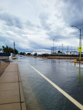Crossroad flooded with running rain water after early morning autumn storm in Phoenix, AZ