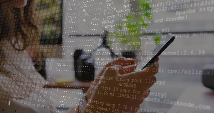 Holding smartphone, female coder scanning ports at desk with monitor and coffee mug, copy space - Powered by Adobe