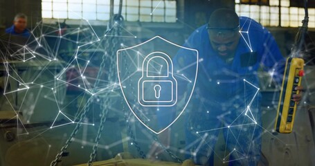 Man in blue coveralls operating hoist using yellow pendant in workshop, network overlay, copy space