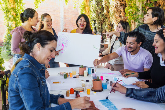 group of latin people in painting classes in a terrace outdoors in Mexico Latin America, multi generational Hispanic and diverse team meeting in art classes - Powered by Adobe