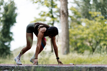 Athlete Preparing for a Sprinting Start Outdoors in a Park