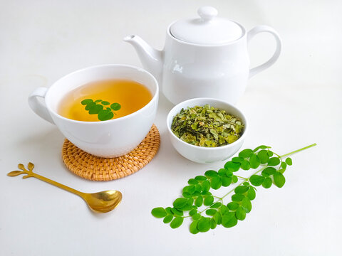 Moringa or Daun kelor herbal drink. A cup of Moringa tea. Boiled moringa leaves water in cup on white background. Healthy drink lifestyle