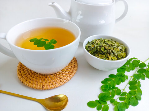 Moringa or Daun kelor herbal drink. A cup of Moringa tea. Boiled moringa leaves water in cup on white background. Healthy drink lifestyle