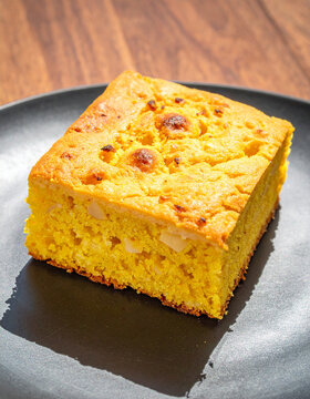 Square Cut of Sopa Paraguaya (Savory Corn Cake) on Polished Black Slate Plate