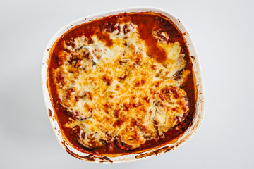 rustic homemade vegetarian eggplant parmigiana in oven tray on kitchen counter