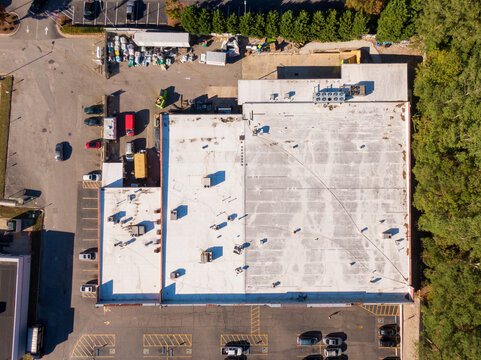 Sunny Daytime Aerial Drone Images of an Old Weathered TPO Roof on a Commercial Building