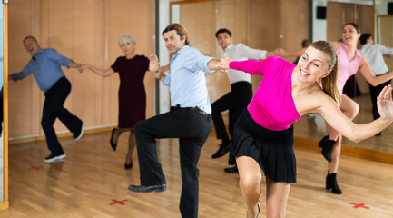 Spirited middle-aged pair training Latino dance during workout session. Pairs training ballroom...