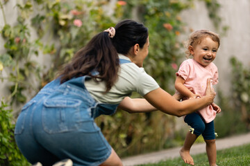 Joyful Caretaker Playing Outdoors with Happy Child in Sunny Garden