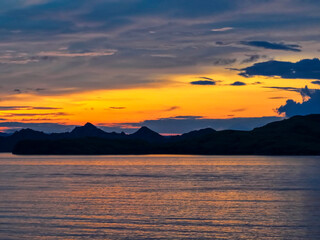 Sunset Over Serene Lake and Mountain Silhouette.