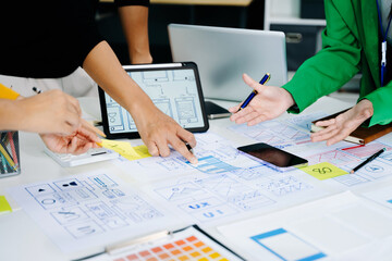 UX developer and ui designer brainstorming about mobile app interface wireframe design with customer breif and color code at modern office.