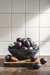 Ripe plums in blue bowl
