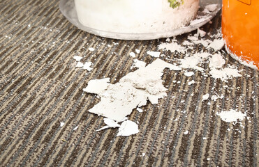 Wet drywall on carpet from water leak in ceiling. Close up of white clumps of drywall next to buckets in residential hallway. Plumbing emergency service concept and burst pipes. Selective focus.