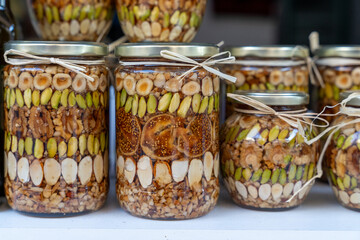 Decorative jars filled with a mix of nuts and dried fruits, showcasing a creative gourmet gift option. ideal for culinary presentations or holiday offerings.