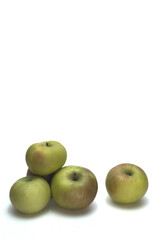 Green apples on a white background.  Vertical layout.  There is a pile of apples to left of frame with a single apple to the right of frame.  There is ample blank space for text. 