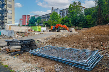 Excavator transforming urban landscape during demolition process near residential buildings