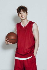 밝은 배경 앞 농구공을 든 남자