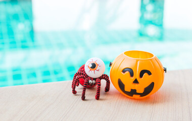 Red spider and eyeball with Halloween pumpkin lantern with space on swimming pool background, outdoor day light, Happy halloween background idea