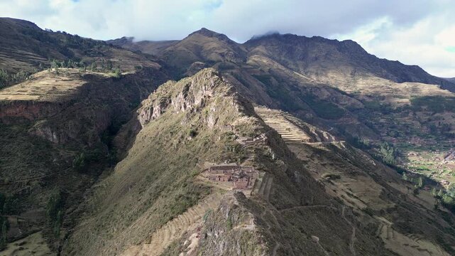 Pisac, Peru: Backward aerial footage along the ridge where Inca Ruins in Pisac Sacred Valley located. Famous archeological site on hilltop near Cusco, Peru 