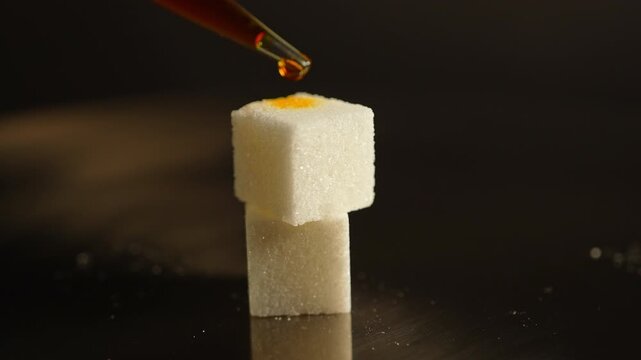 LSD in liquid dropped from pipette to sugar. Lysergic acid diethylamide known as LSD. Also named Acid, lucy, or Ellis D. Semisynthetic hallucinogenic drug made of ergot fungi.