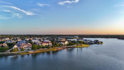 Aerial view of a town with luxurious houses next to Woodlands lake in Houston, United States by sunset time