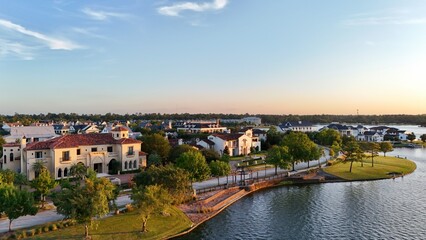 Aerial view of a town with luxurious houses next to Woodlands lake in Houston, United States by sunset time
