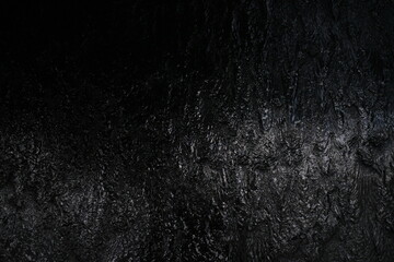 Black background, created by water flowing from the top, black wall as a waterfall.