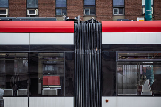Close detail of a Toronto streetcar shows the articulated bellows, with windows at platform height, on public transit design and urban transportation. toronto tram is a transit system in Canada.
