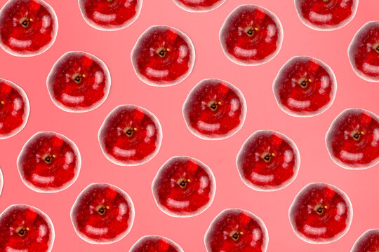 Vibrant red apples form a seamless repeating pattern against a monochromatic pink background. - Powered by Adobe