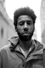 Obraz premium Young man with afro hair posing in the street in black and white analog photo