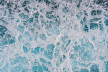 Dark blue ocean texture with marine splashes and foamy waves showing deep clear water surface and natural sea background