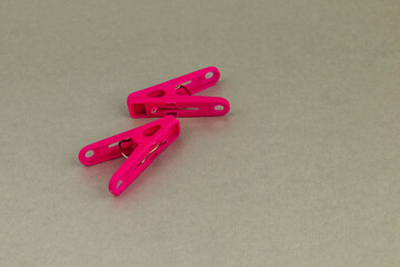 Vibrant pink clothespins arranged on a textured surface