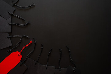 Black Friday concept with a single red tag stands out among black tags on a dark background for sale text.